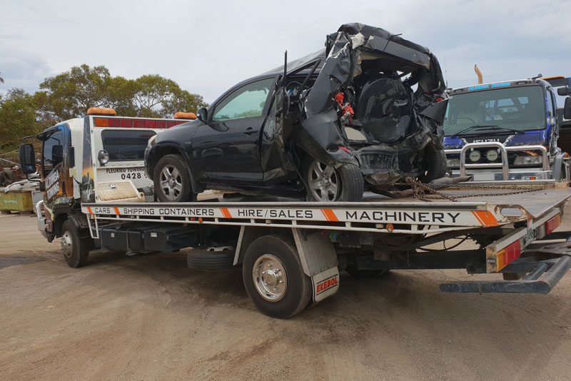 Cash for cars - A tow truck towing a car that has been in a rear end crash