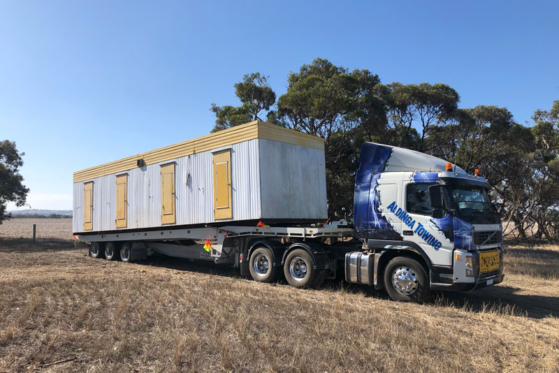 Tranportable offices loaded onto a tilt tray heavy haulage truck 