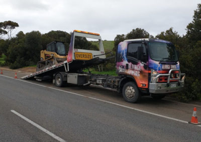 An oversized heavy haulage tow trucks transporting a small excavator